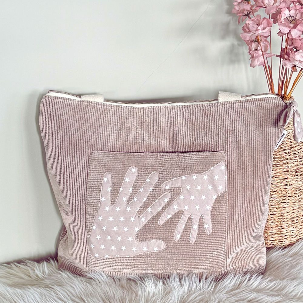 memory bag van ribcord stof taupe met handen een tas vol herinneringen  BYDINE