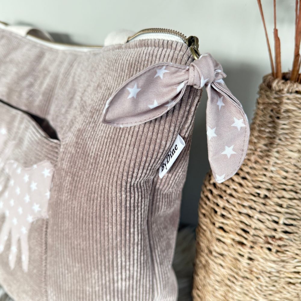 memory bag van ribcord stof taupe met handen een tas vol herinneringen  zijkant BYDINE