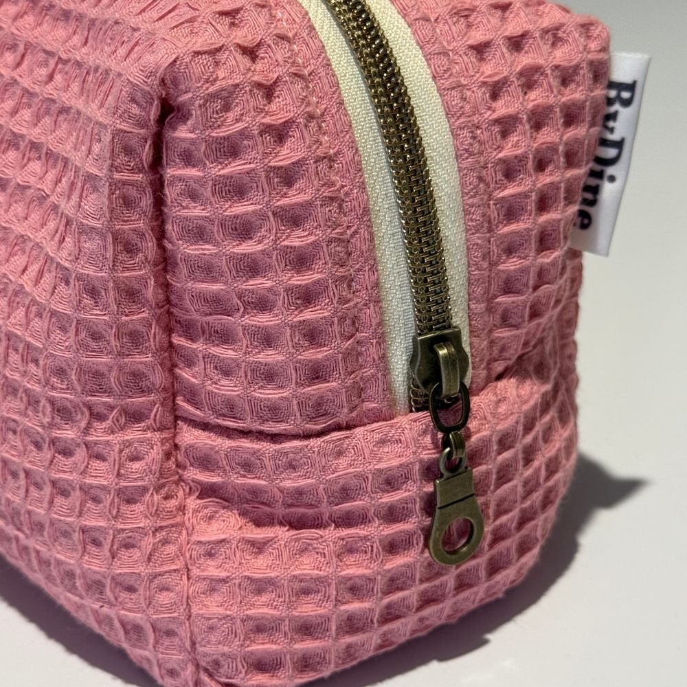 Roze mousseline make-up tas gewatteerd met  een bloemige binnenkant  zijkant BYDINE