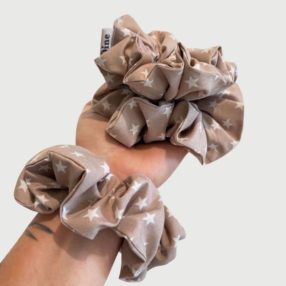 Scrunchie in taupe kleur met witte kleine sterren van katoen gedragen om arm BYDINE